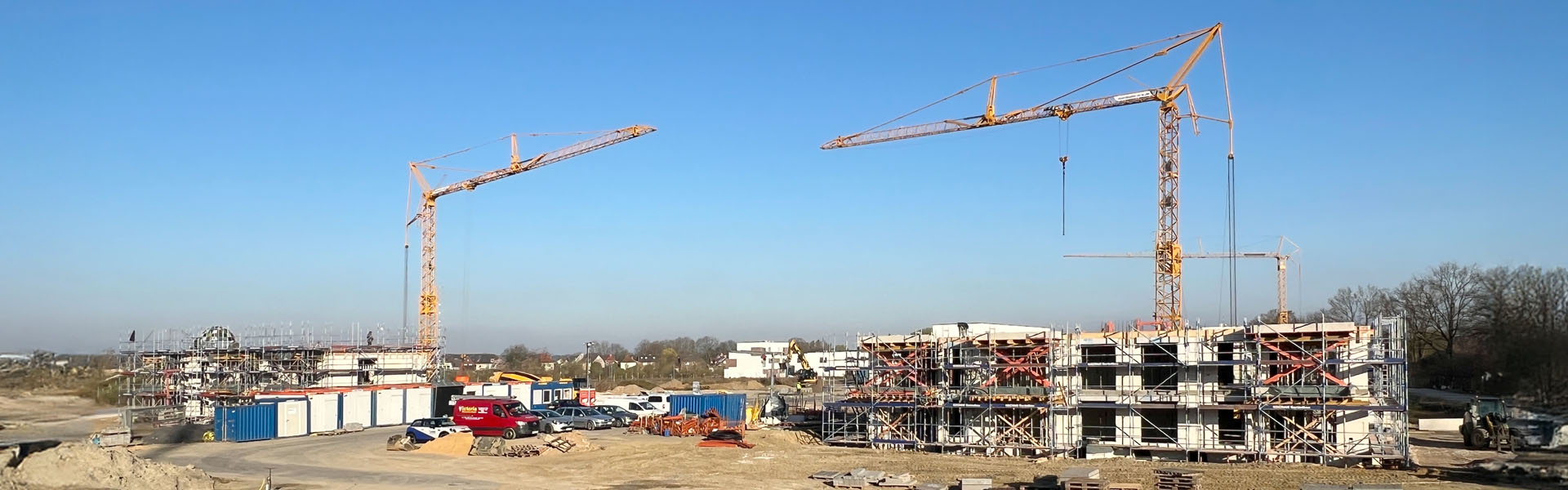 Eine Baustelle mit Rohbauten, Gerüsten sowie Baukränen.